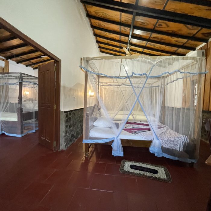 Interior of the family bungalow with two double beds and mosquito nets